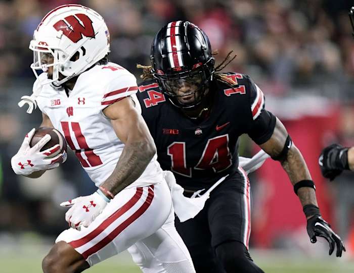 Sep 24, 2022; Columbus, Ohio, USA; Ohio State Buckeyes safety Ronnie Hickman (14) tackles Wisconsin Badgers wide receiver Skyler Bell (11) in the third quarter of the NCAA football game between Ohio State Buckeyes and Wisconsin Badgers at Ohio Stadium. Ncaa Football Wisconsin At Ohio State